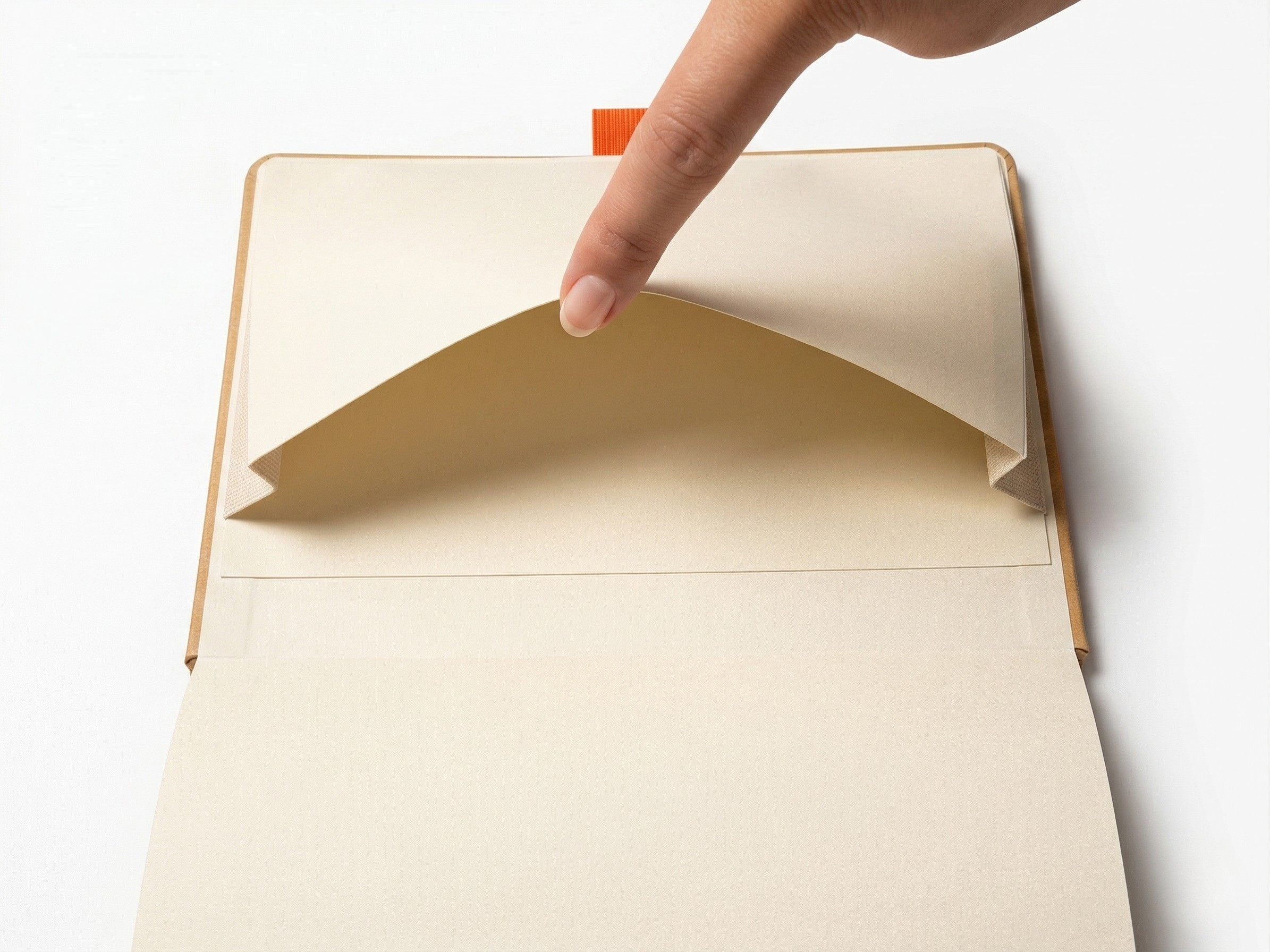 Hand opening a beige notebook with a white background